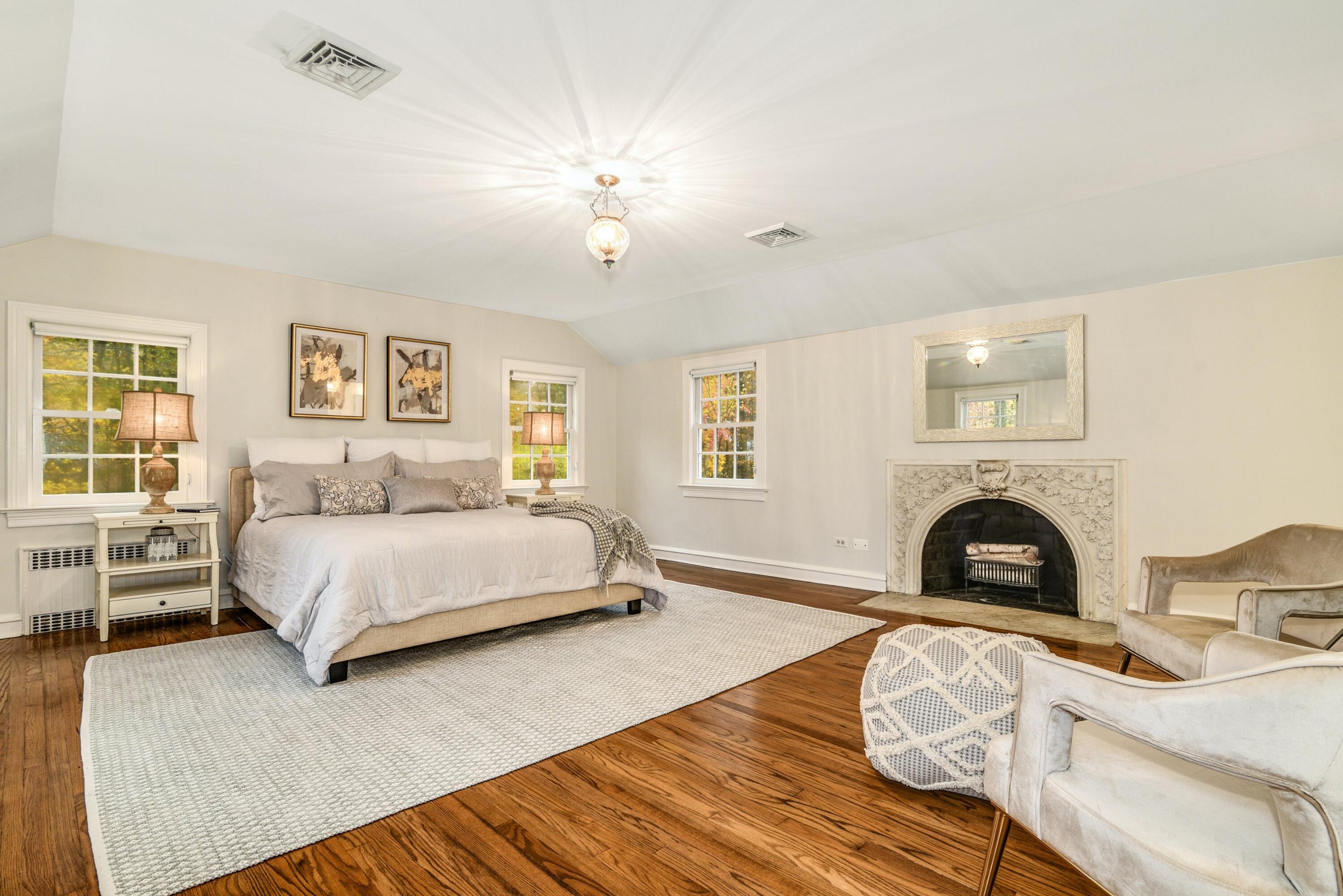22 Stony Brook Road Darien, CT 06820 - Photo 22 of 33 a bedroom with a bed and a fireplace