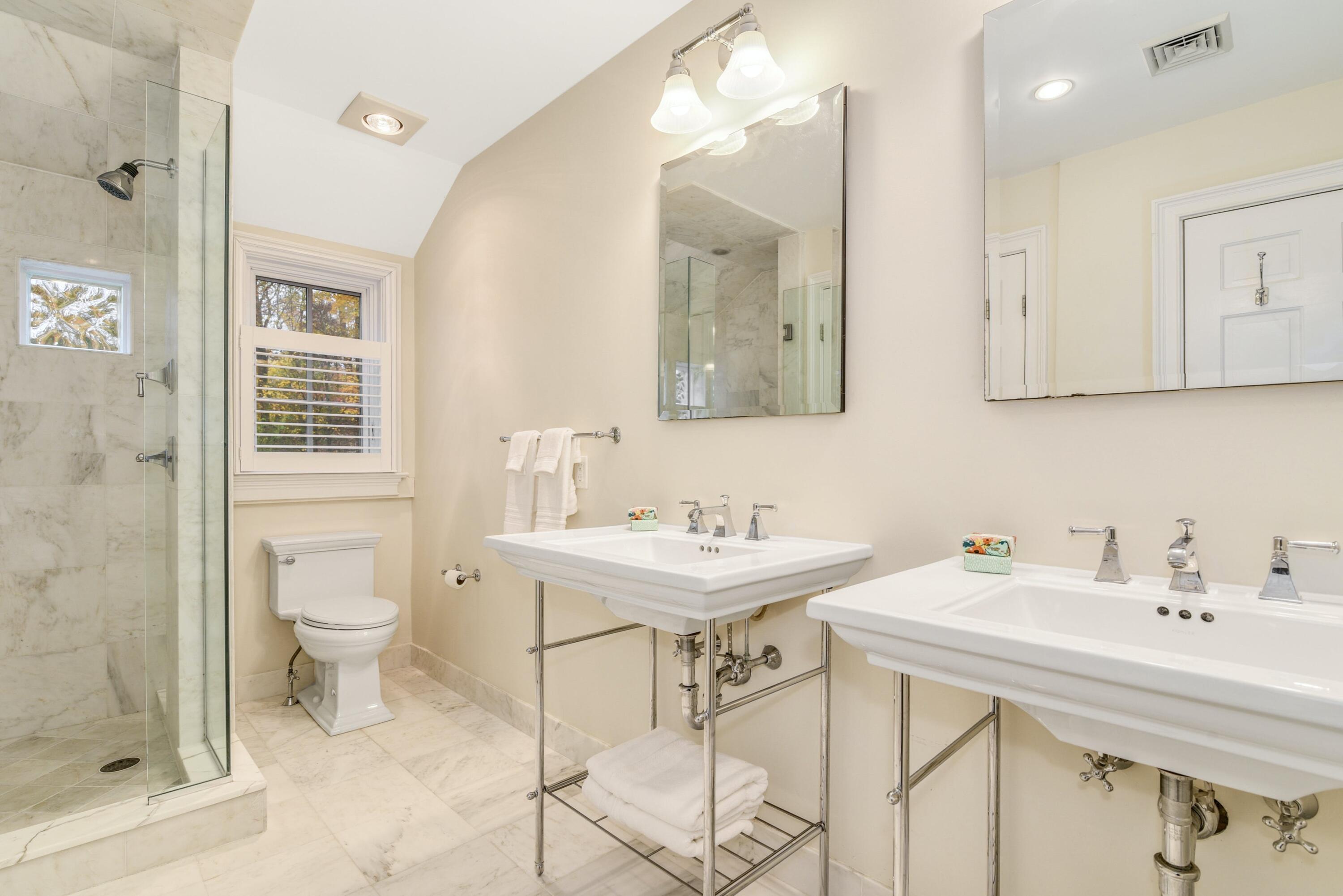 22 Stony Brook Road Darien, CT 06820 - Photo 24 of 33 a bathroom with a toilet a sink a mirror and a shower