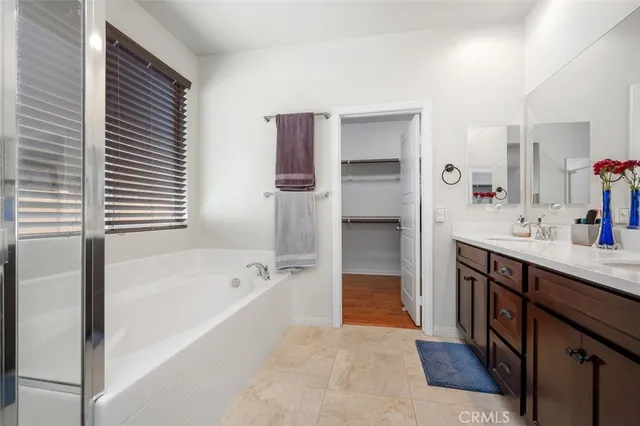 a spacious bathroom with a tub sink and mirror