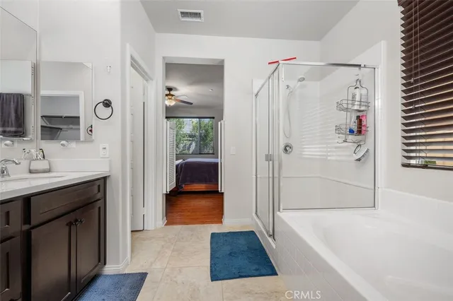a bathroom with a tub shower sink and mirror