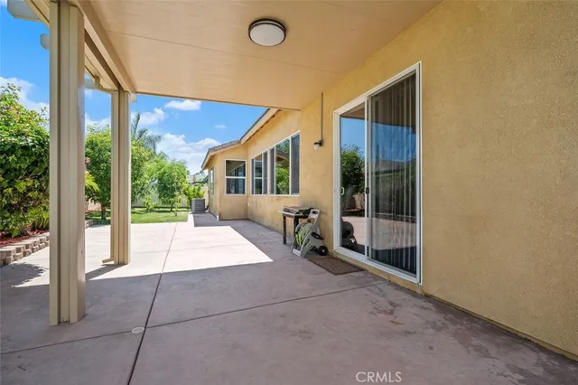 a room with a large window and potted plants