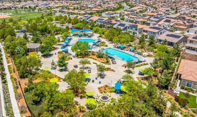 an aerial view of residential houses with outdoor space and trees