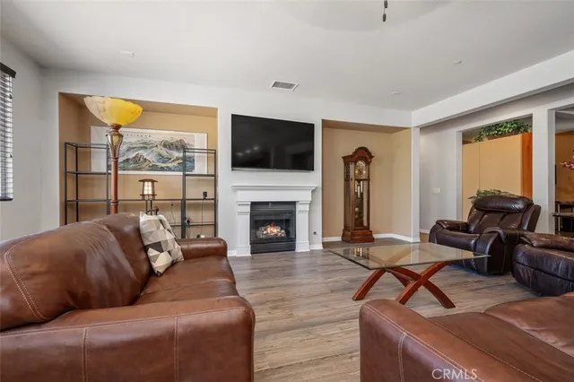 a living room with furniture a fireplace and a flat screen tv