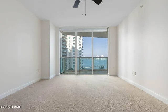 an empty room with windows and ceiling fan