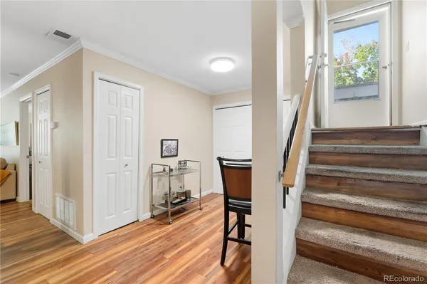 a view of a hallway with wooden floor and staircase