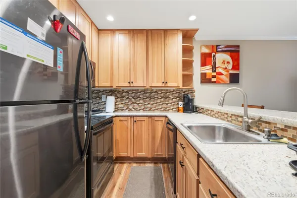 a kitchen with stainless steel appliances granite countertop a refrigerator and a sink