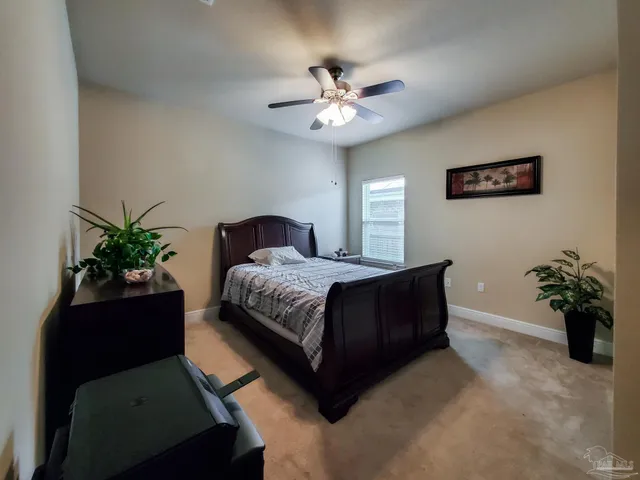 a bedroom with a bed and a potted plant
