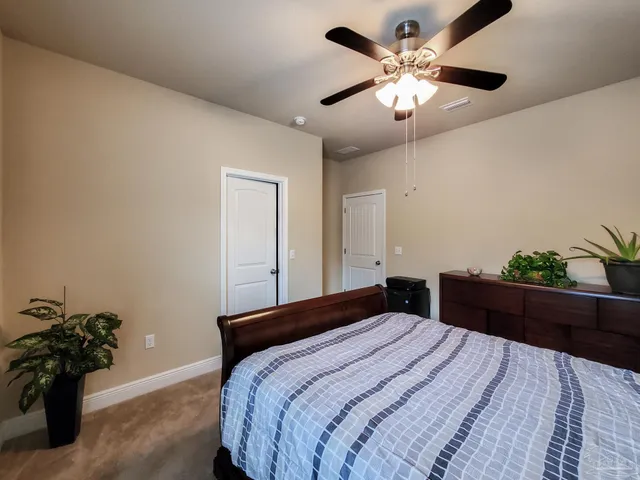 a bedroom with a bed and a potted plant