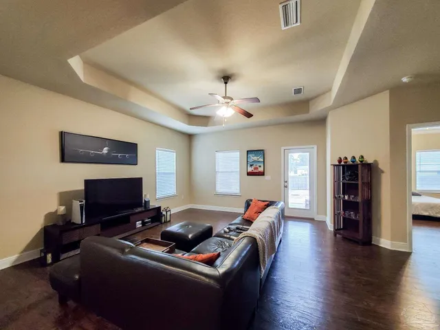 a living room with furniture a bookshelf and a flat screen tv