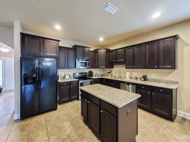a kitchen with a refrigerator sink cabinets and a sink