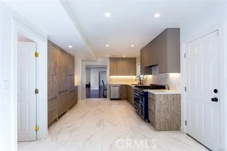 a large kitchen with stainless steel appliances granite countertop a stove a sink and a refrigerator