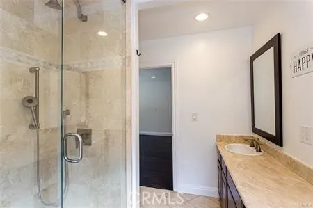 a bathroom with a granite countertop sink shower and a mirror