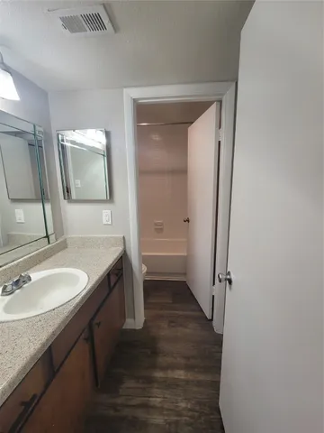 a bathroom with a granite countertop sink toilet and shower