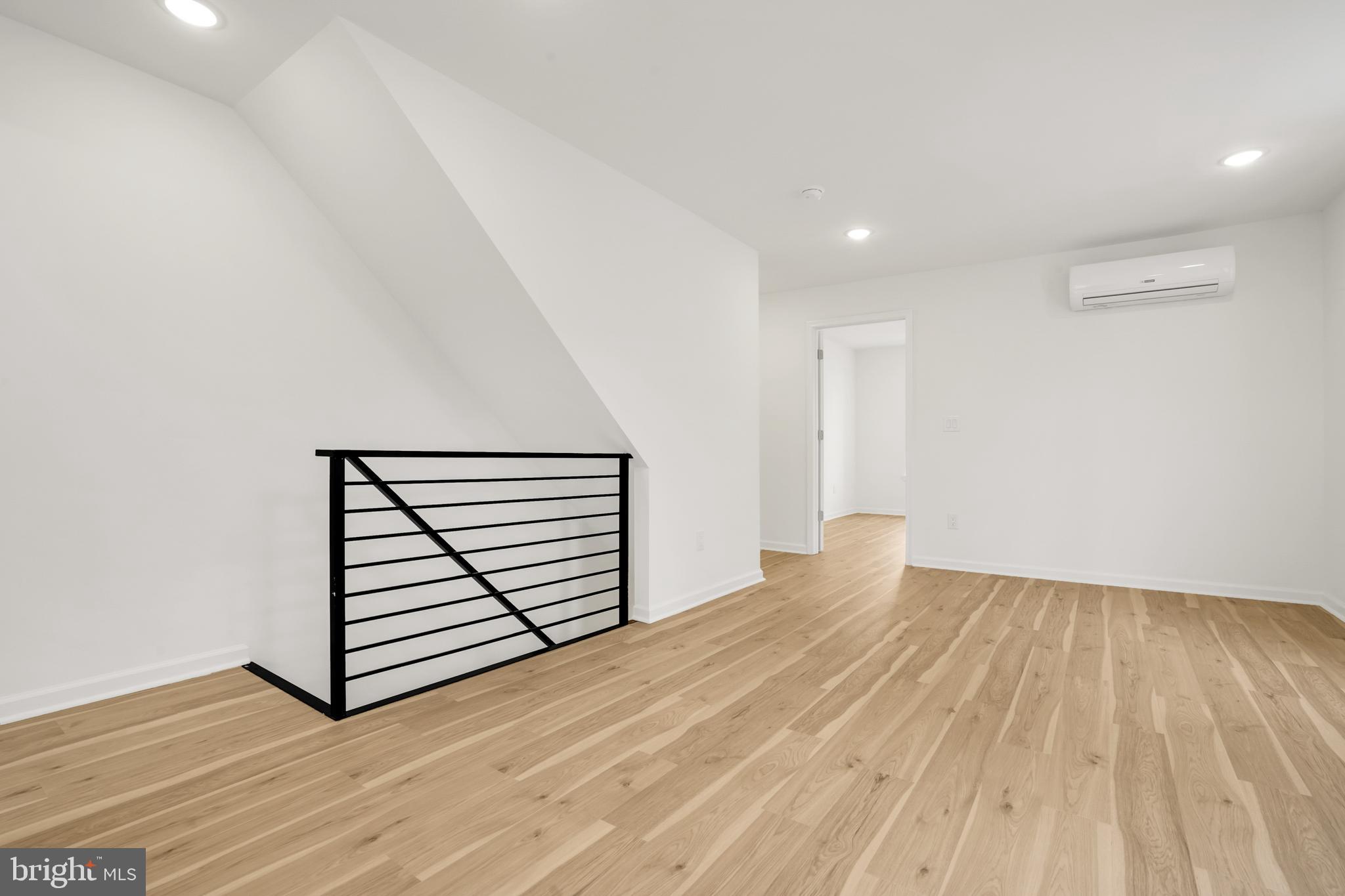 a view of a room with wooden floor and white walls