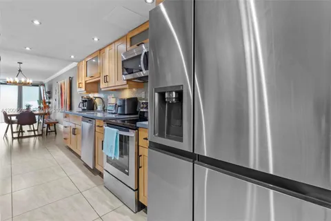 a kitchen with stainless steel appliances granite countertop a refrigerator and a stove
