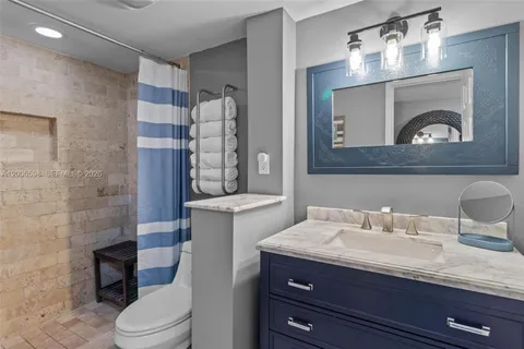 a bathroom with a granite countertop toilet sink and mirror