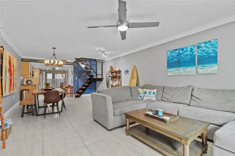 a living room with furniture a chandelier and a flat screen tv