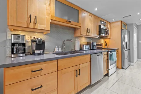 a kitchen with stainless steel appliances granite countertop a sink a stove and a refrigerator