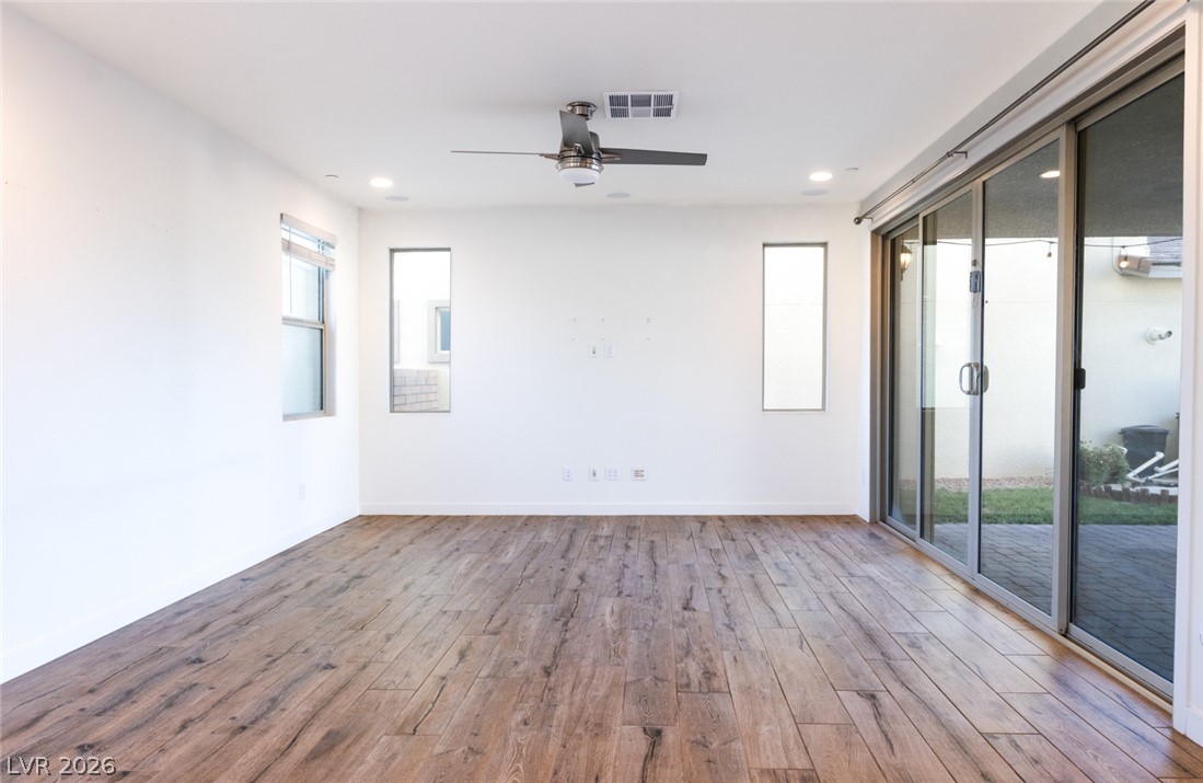 920 East Sunset Road Henderson, NV 89011 - Photo 6 of 33 Hardwood flooring extends throughout this naturally illuminated living space, opening to a private patio through sliding glass doors.