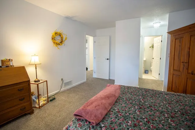 a bedroom with a bed and painting on the wall