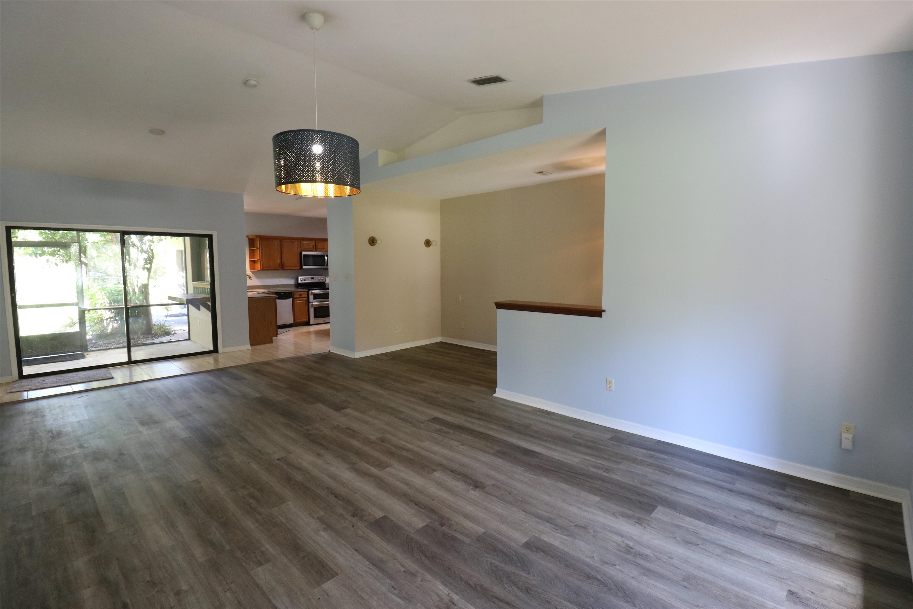 5861 Datil Pepper Road St. Augustine, FL 32086 - Photo 14 of 27 Unfurnished living room featuring dark wood-type flooring and high vaulted ceiling