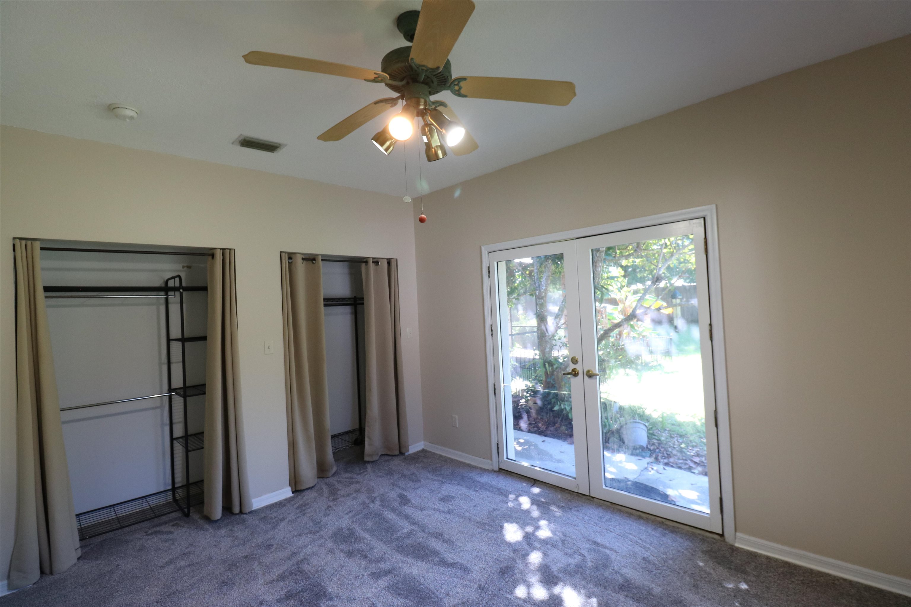 5861 Datil Pepper Road St. Augustine, FL 32086 - Photo 22 of 27 Unfurnished bedroom featuring multiple closets, carpet floors, ceiling fan, french doors, and access to exterior