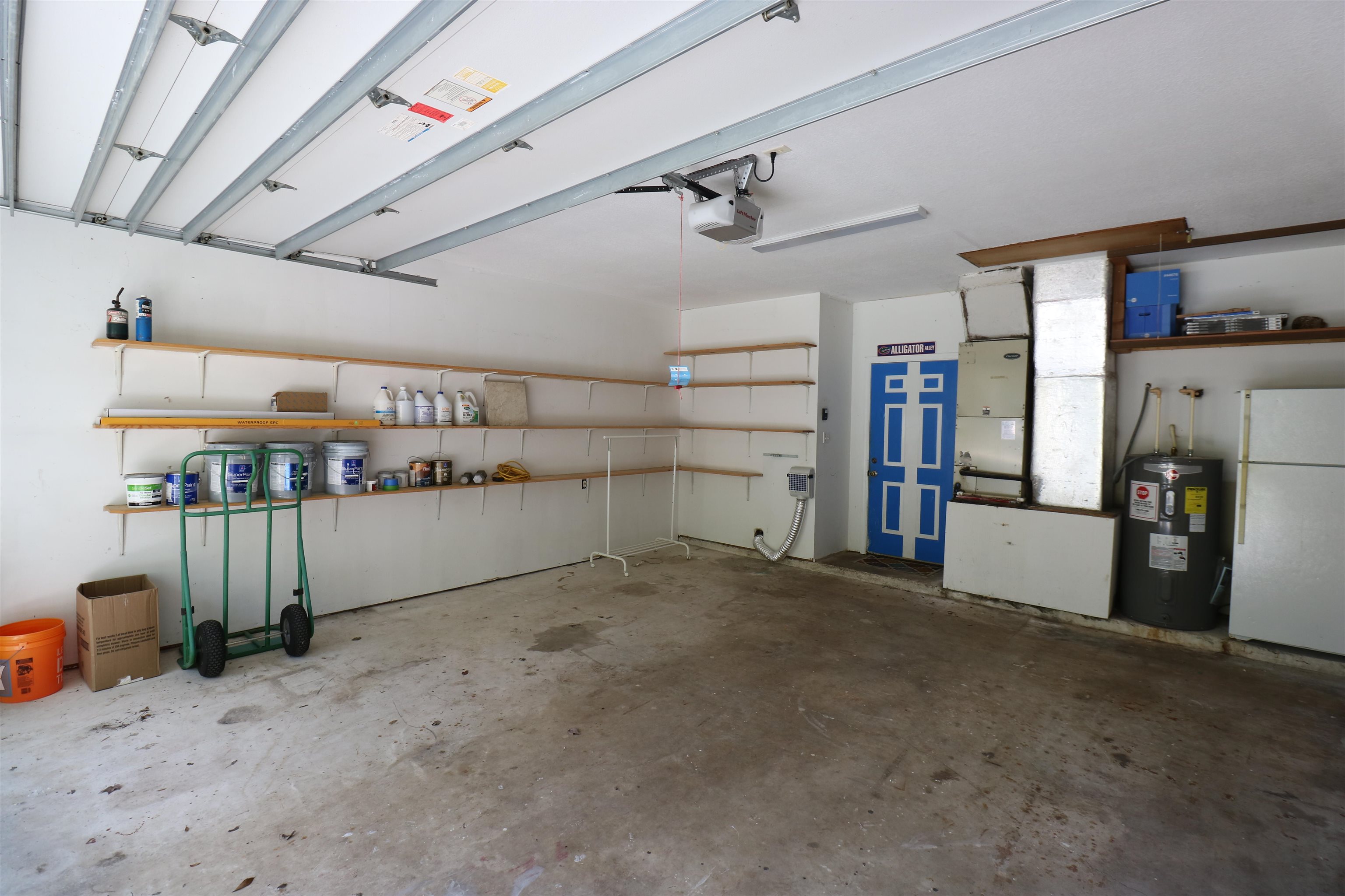 5861 Datil Pepper Road St. Augustine, FL 32086 - Photo 24 of 27 Garage with freestanding refrigerator, electric water heater, heating unit, and a garage door opener