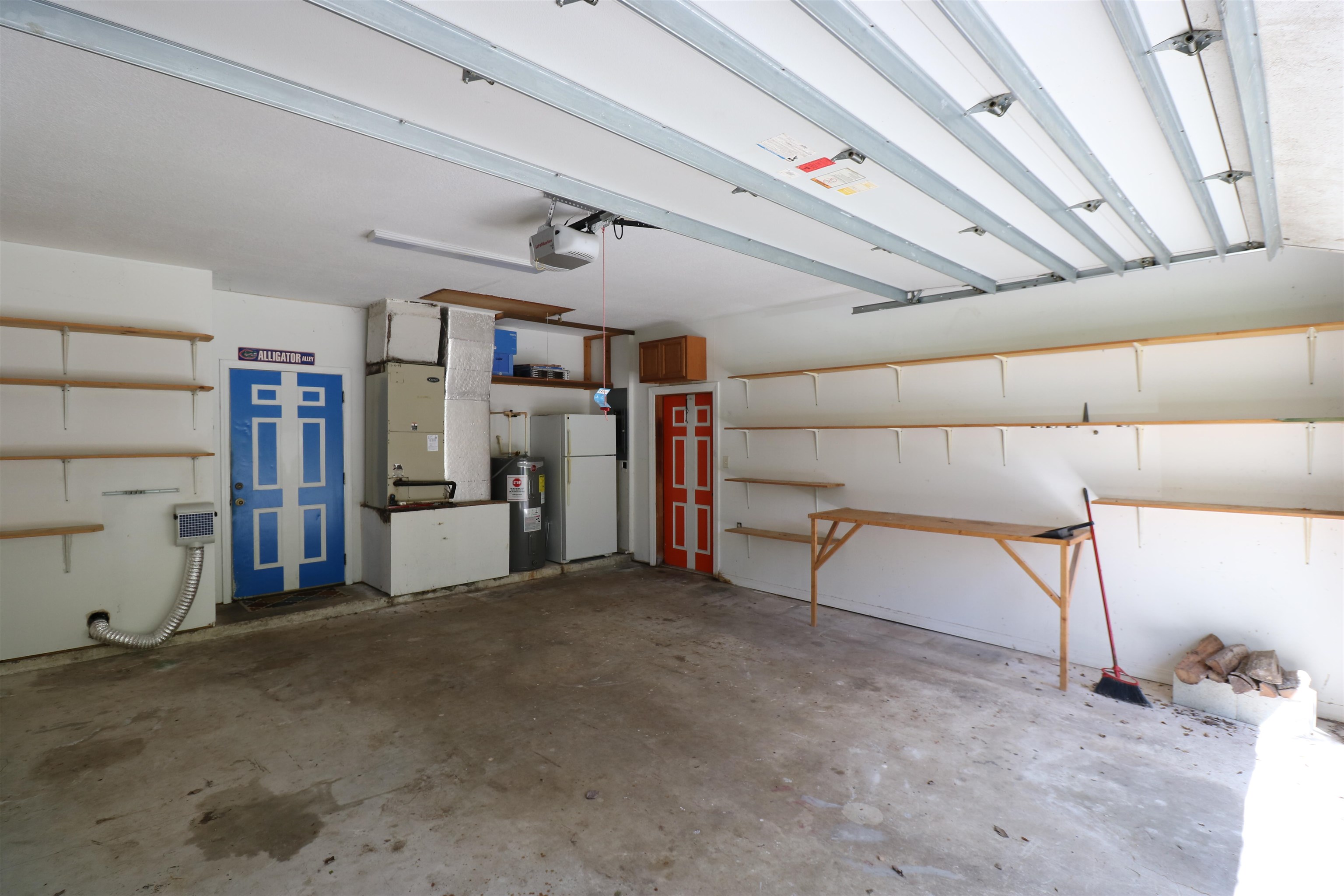 5861 Datil Pepper Road St. Augustine, FL 32086 - Photo 25 of 27 Garage featuring freestanding refrigerator, electric water heater, heating unit, and a garage door opener