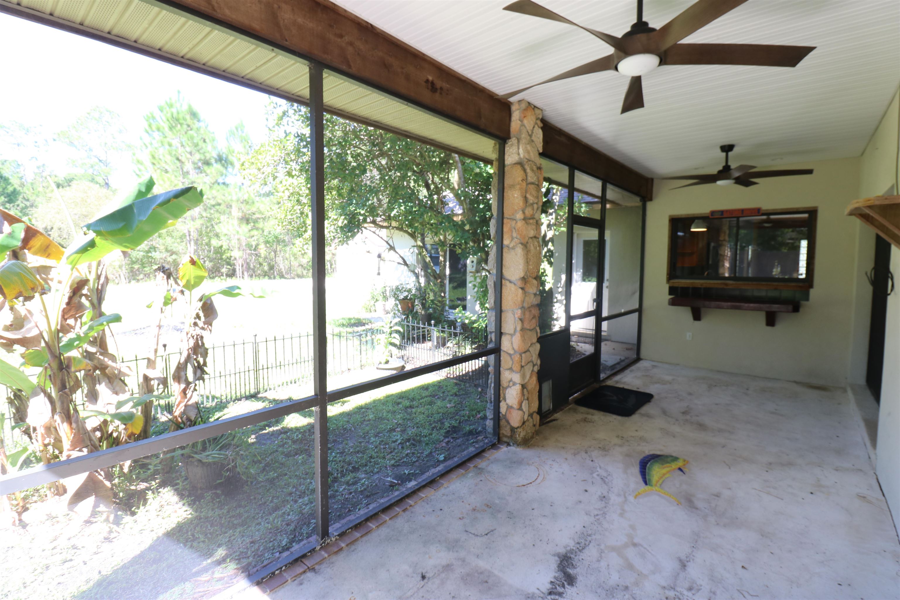 5861 Datil Pepper Road St. Augustine, FL 32086 - Photo 27 of 27 Unfurnished sunroom featuring unfinished concrete flooring and a ceiling fan