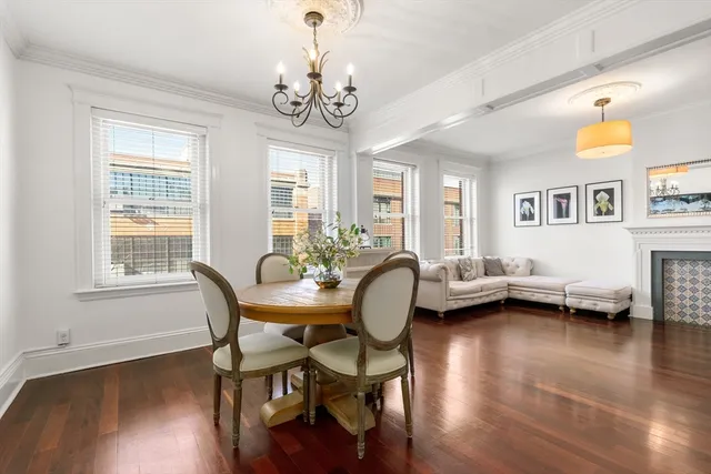 a view of a dining room with furniture a chandelier and wooden floor