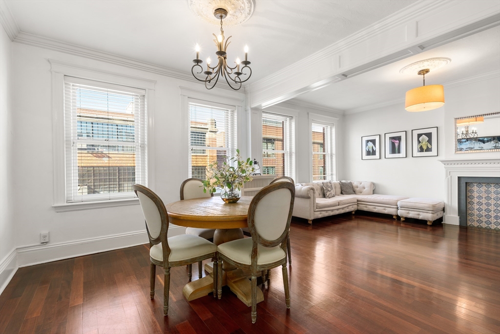 a view of a dining room with furniture a chandelier and wooden floor