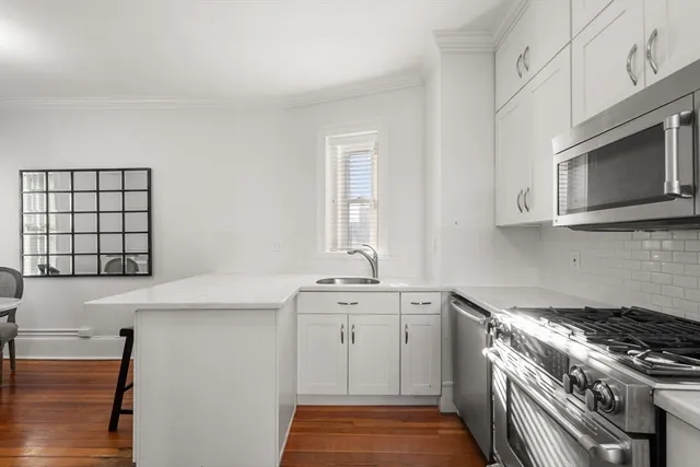 a kitchen with white cabinets and sink