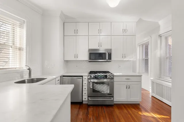 a kitchen with stainless steel appliances white cabinets and a stove
