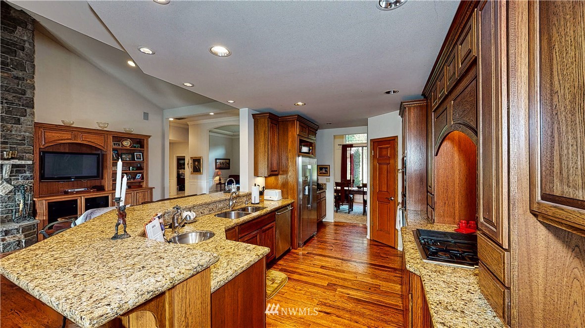 4830 Fobes Road Snohomish, WA 98290 - Photo 19 of 35 a large kitchen with stainless steel appliances granite countertop plenty wooden cabinets counter space and wooden floor