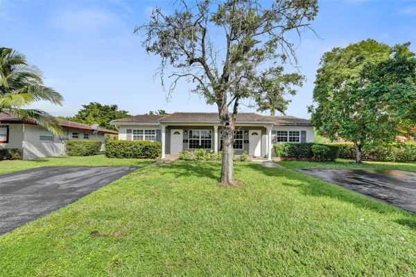 a front view of a house with yard and green space