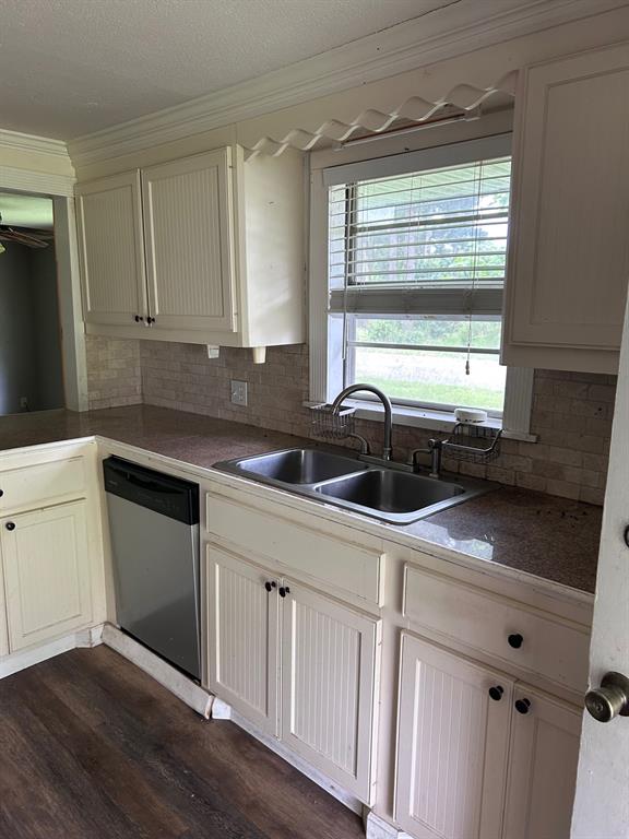 1330 Palmetto Road Benton, LA 71006 - Photo 4 of 13 Kitchen with decorative backsplash, ornamental molding, stainless steel dishwasher, dark wood-type flooring, and a textured ceiling
