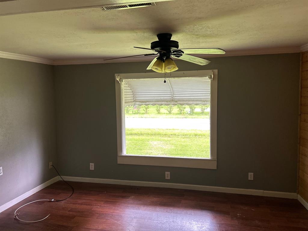 1330 Palmetto Road Benton, LA 71006 - Photo 7 of 13 Unfurnished room with crown molding, dark wood finished floors, and ceiling fan
