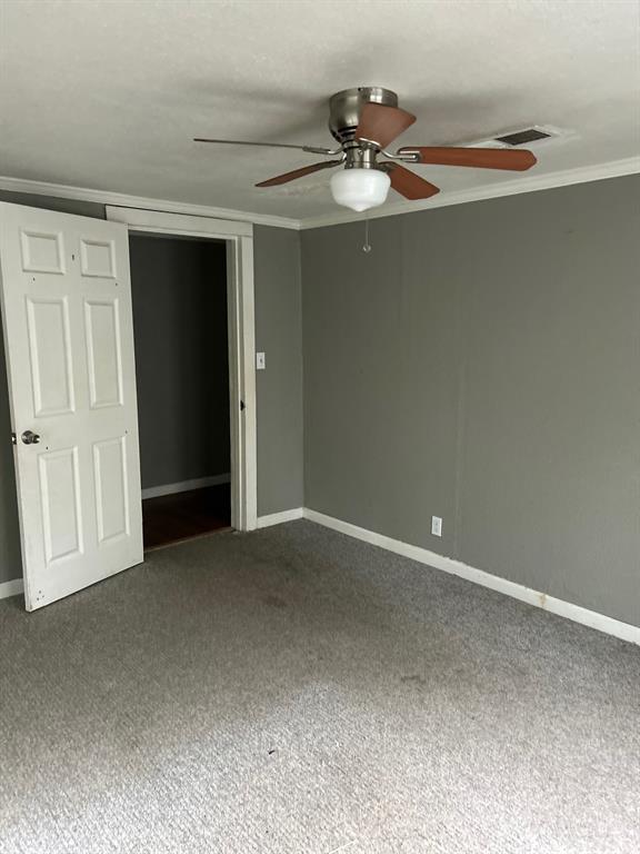 1330 Palmetto Road Benton, LA 71006 - Photo 10 of 13 Unfurnished bedroom featuring ornamental molding, carpet flooring, a ceiling fan, and a closet