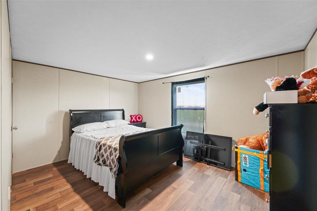 0 Ewing Road Ferris, TX 75125 - Photo 17 of 29 Room featuring wood-finish flooring, neutral wall paneling, and a single window