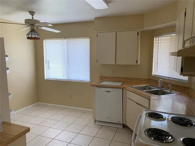 a white refrigerator freezer and a stove sitting inside of a kitchen