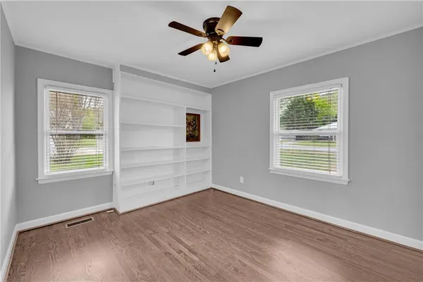 a view of an empty room with a window and a ceiling fan