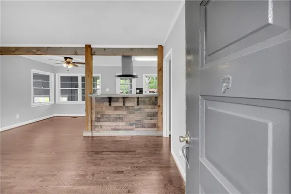 a view of a hallway with wooden floor and a living room