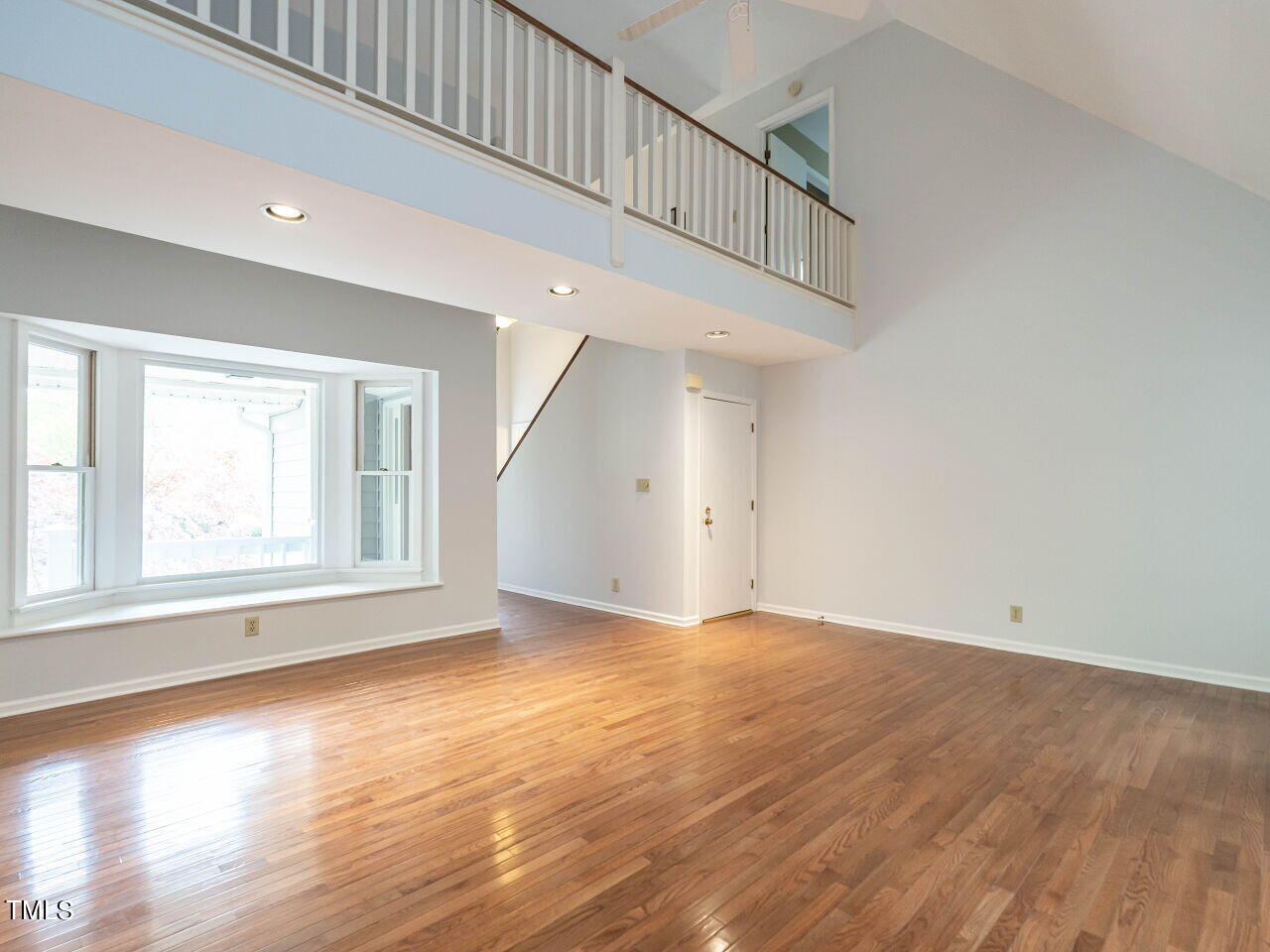 3309 Cobblestone Court Raleigh, NC 27607 - Photo 6 of 38 a view of an empty room with wooden floor and a window