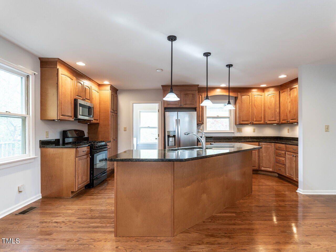 3309 Cobblestone Court Raleigh, NC 27607 - Photo 8 of 38 a kitchen with stainless steel appliances granite countertop a sink a stove top oven a counter space and cabinets