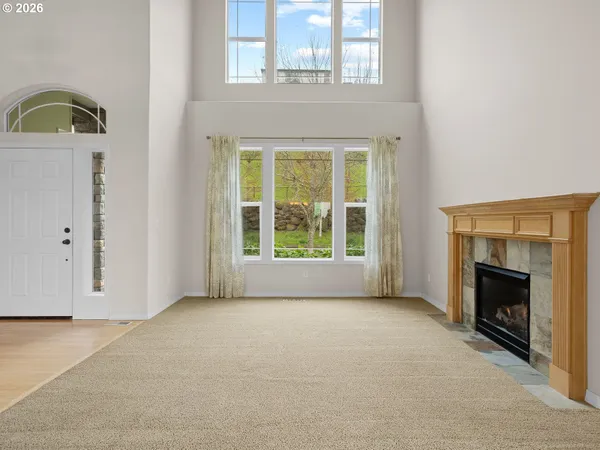 a view of an empty room with window and fire place