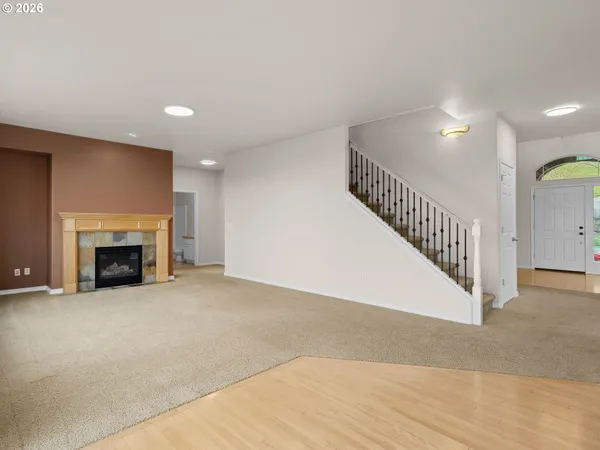 a view of an empty room with wooden floor a fireplace