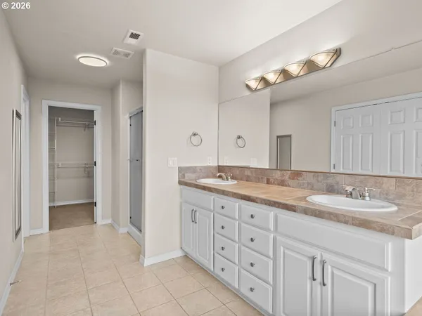 a spacious bathroom with a granite countertop sink a mirror and a shower