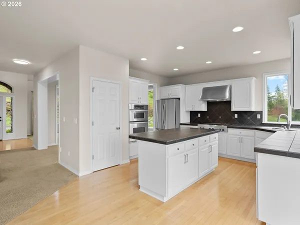 a large kitchen with stainless steel appliances granite countertop a large counter top and a stove top oven