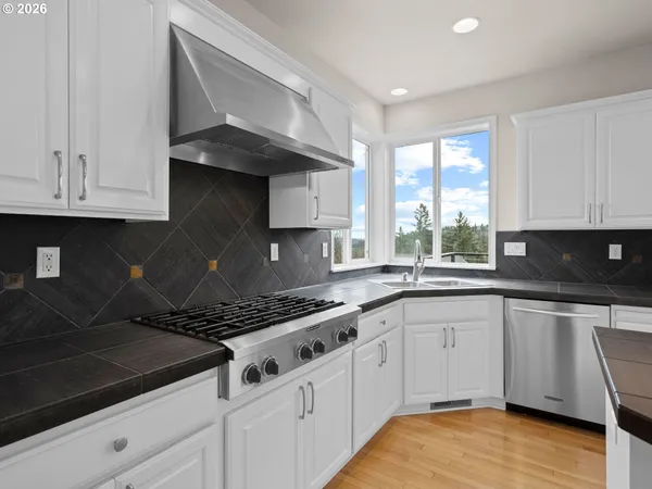 a kitchen with granite countertop a sink a stove and cabinets