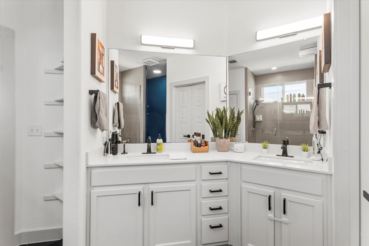 6912 Cardinal Bloom Loop Austin, TX 78744 - Photo 27 of 33 Dual vanities with pristine white countertops offer abundant personal space in this well-appointed bathroom.